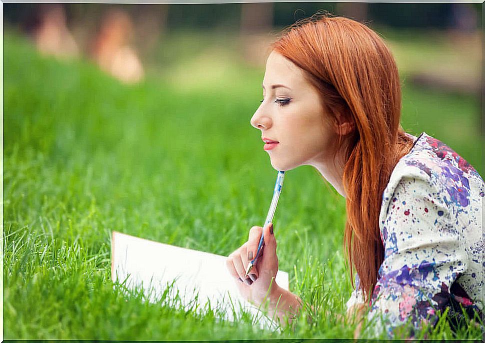 Woman on grass writing