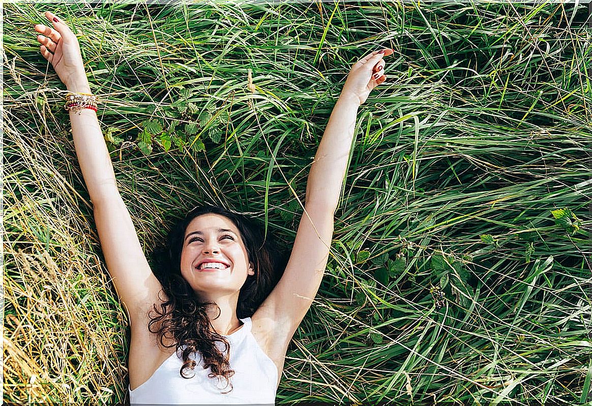 Woman lying in the field happy