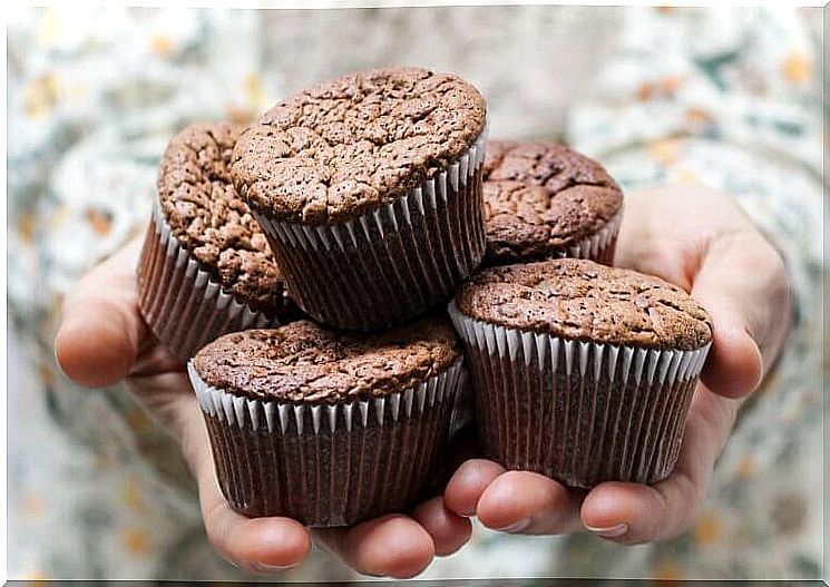 Hands with five chocolate muffins