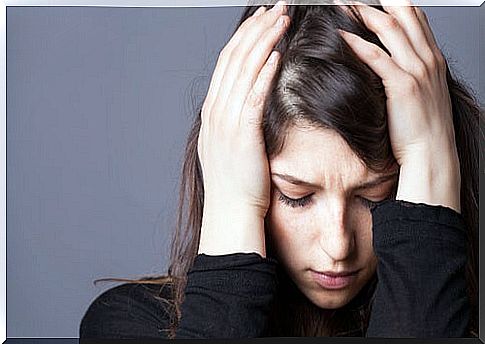 Woman clutching her head with her hands worried