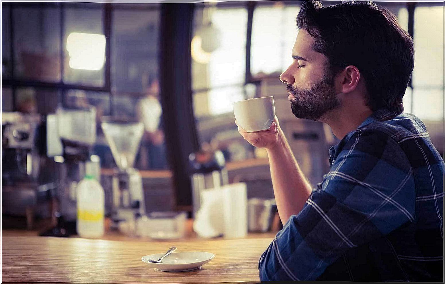 man smelling coffee cup