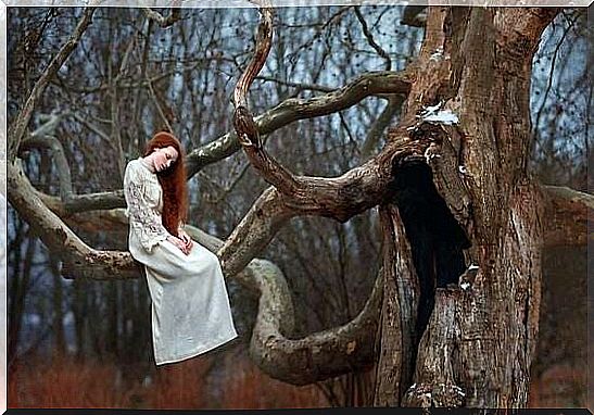 Sad woman in a tree thinking about her demons