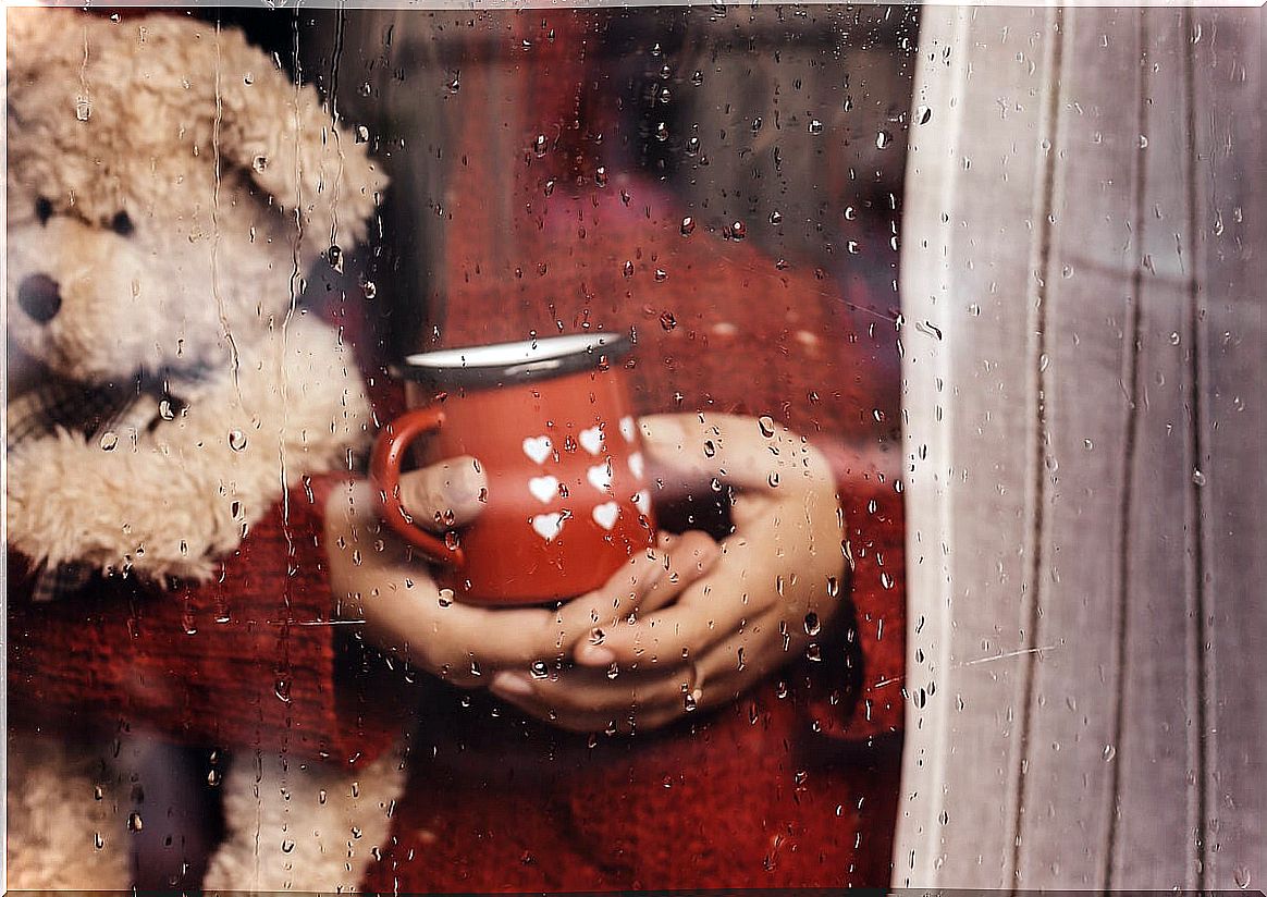 Person watching rain from window