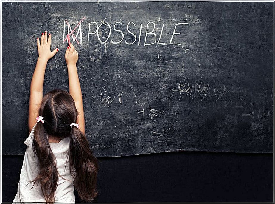 Little girl painting on a blackboard