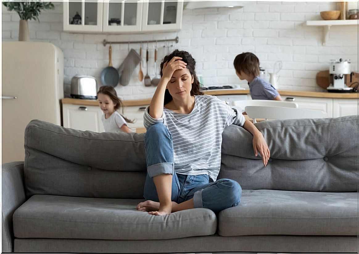 Woman burdened by her children who suffers parental burnout