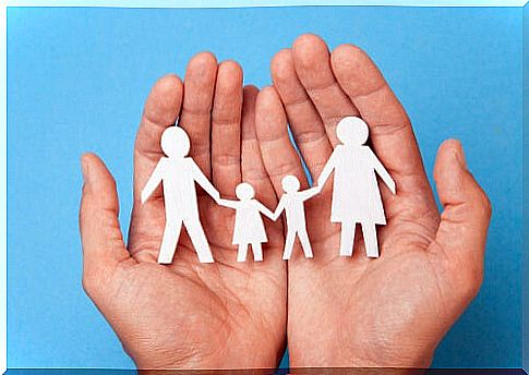 Hand holding figures in the shape of resilient families