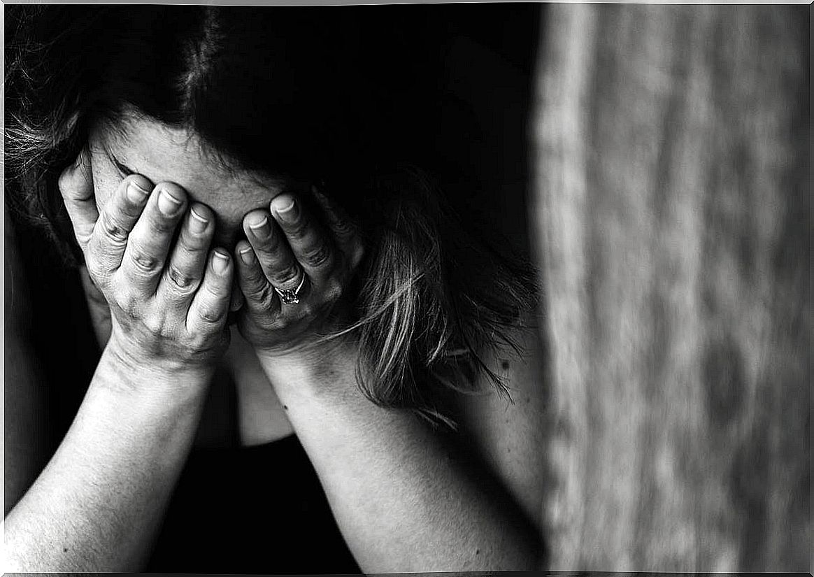 Woman covering her face to represent the relationship between shame and depression