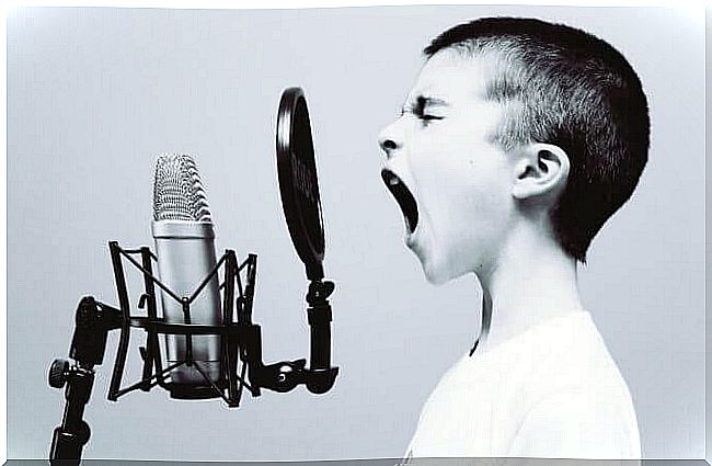 boy raising his voice while speaking into microphone