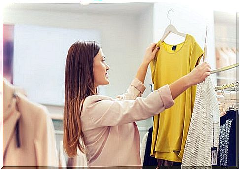 Woman buying clothes to represent consumerism in the fashion world